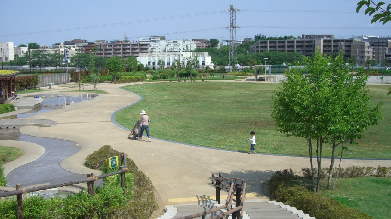 鷺沼ふれあい広場(川崎市宮前区)の芝生広場と水遊び場、奥に広がる住宅地(2009年撮影)