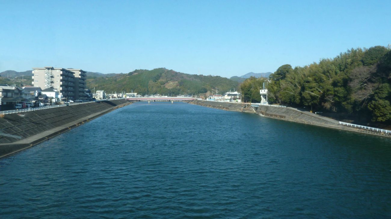青空の下の鏡川と山並み(高知県高知市、2011年撮影)